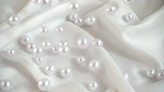 Pearls fall on silk. Slow motion.