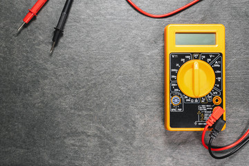 Multimeter and cables on gray flat lay background with copy space.