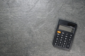 Black calculator on dark flat lay background with copy space.