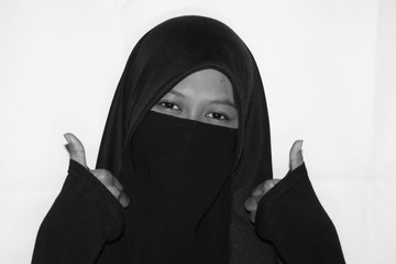 Close up view of Pretty lady woman girl wear hijab jilbab niqab kerudung niqaab scarf cover face and only show visible look of her beauty eyes. Fit for put design life image. Black white  with grain t