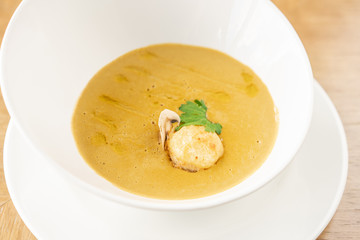 Cream-soup with porcini mushroom with croutons on wooden table. Restaurant menu