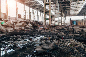 Old rotten Soviet gas mask on durty floor of abandoned factory, selective focus