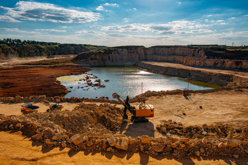 Excavarors working on limestone mining in the flooded quarry