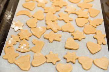cookie cut in different shape for gingerbread cookies on the pan.cooking concept.
