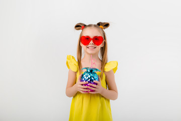 happy child girl in sunglasses holding a glass with a cocktail on a white background isolate