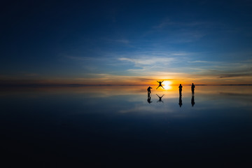 Uyuni Salt Flat, Bolivia, South America - Silhouettes of Tourists taking photos at sunrise having...