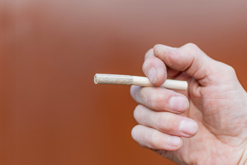 The hand of a working man holding a cigarette