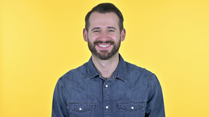 Obraz premium Portrait of Cheerful Young Man Smiling at Camera, Yellow Background