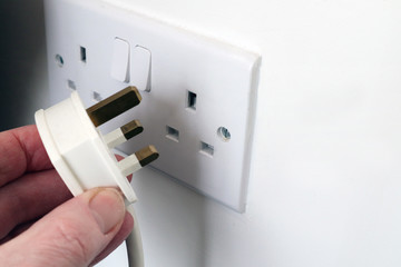Hand putting a plug in/out of a socket