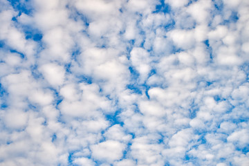 Obraz premium Small white clouds high in the blue sky