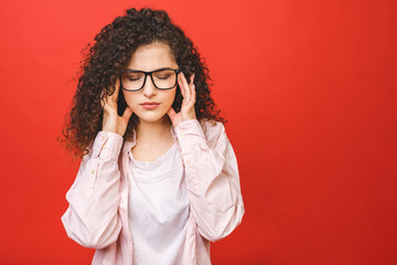 Portrait of beautiful student woman tired at work, isolated on a red background.