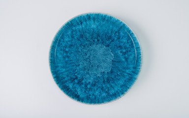 Empty blue ceramic round plate isolated on white background