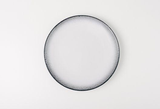 Empty white ceramic round plate isolated on white background