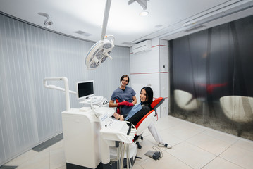 Doctor and patient look at the camera, smile health. Dentistry