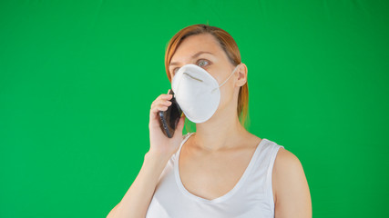 Woman in medical mask is cheking her phone for medical advice and information protecting her from virus, pollution. Protective medical mask from coronavirus epidemic in Europe and Asia.