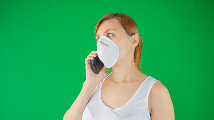 Woman in medical mask is cheking her phone for medical advice and information protecting her from...