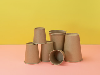 Biodegradable disposable tableware in yellow and pink background.