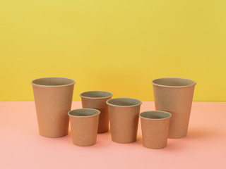 Eco-friendly disposable tableware in pink and yellow background.
