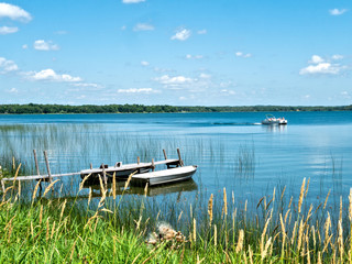 Beautiful Minnesota lake scene with reeds on shore, two aluminum fishing boats bobbing gently at a...