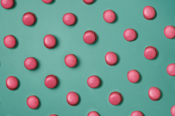 Pink macaroons four types pattern on blue green background 