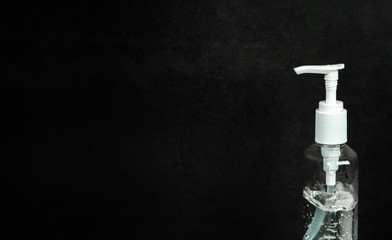 bottle of hand sanitizer, hand disinfecting gel, crucial for coronavirus prevention through antibacterial hygiene. Coronavirus preventing concept on dark black  background