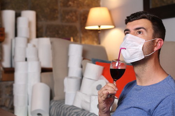 Man quarantining at home with toilet paper and alcohol 