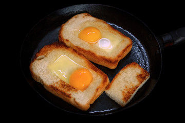 Fried toasts with egg inside in a pan. Traditional french dish. Rustic breakfast