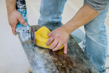 A construction worker cutting a tile using grinder