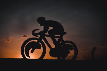 Fototapeta na wymiar silhouettes of bikers on sunset background of mountains