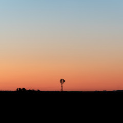 Silhouette of a windmill at sunset