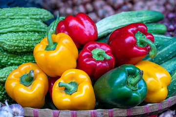 Green, yellow and red sweet peppers for sale at street food market in Vietnam. Close up