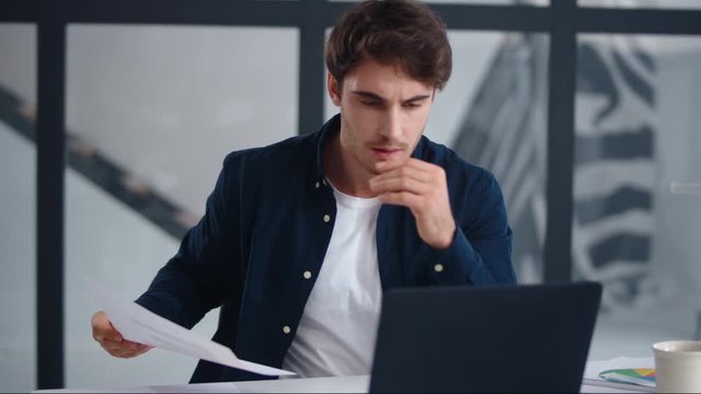 Upset businessman finding mistakes in documents. Sad guy looking papers indoor