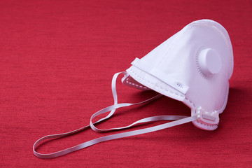White ffp3 face mask with a valve on a red background