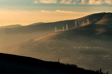 Landscape of Marão in Portugal, at sunset on a winter afternoon, with the wind farm highlighted by...