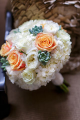 Orange and white rose bridal bouquet on a chair