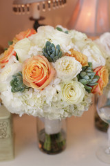 Orange and white rose bridal bouquet on a chair