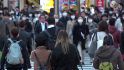 TOKYO, JAPAN - MARCH 2020 : Crowd of people at the street near Shinjuku station in rush hour. Commuters and tourists wearing surgical mask to protect from Coronavirus(COVID-19) or cold. Slow motion. - Powered by Adobe