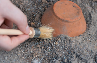 archeology . Male hand holding brush. brush; excavation of rare pots and villages. tools for the excavation and culture of ancient settlements and caves. Elements of Culture BC