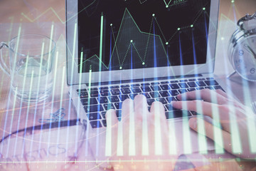 Multi exposure of market chart with man working on computer on background. Concept of financial analysis.