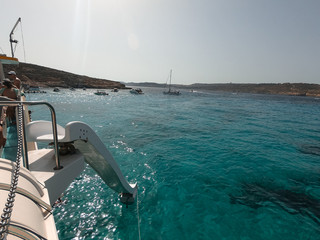 Naklejka premium Residents and tourists enjoy at Comino Beach, Malta. One of the most visited beaches in Malta, where most people enjoy the weather, beaches and attractions.