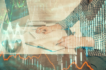 Double exposure of stock market chart with man working on computer on background. Concept of financial analysis.