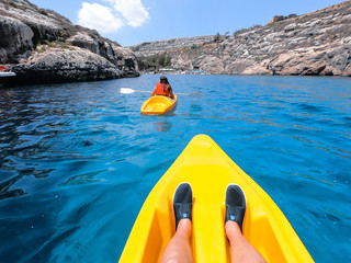 Tourists practicing kayaking on one of the beaches on the island of Gozo, Malta. People enjoying...