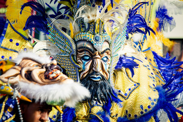 closeup man in pied masquerade costume walks by city street at dominican carnival
