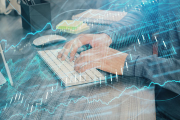 Stock graph with businessman typing on computer in office on background. Concept of analysis. Double exposure.