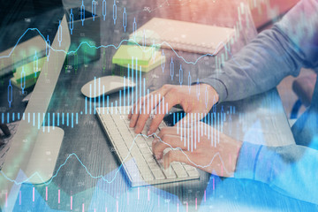 Stock graph with businessman typing on computer in office on background. Concept of analysis. Double exposure.