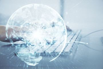 Double exposure of businessman working on laptop on background. International business hologram in...