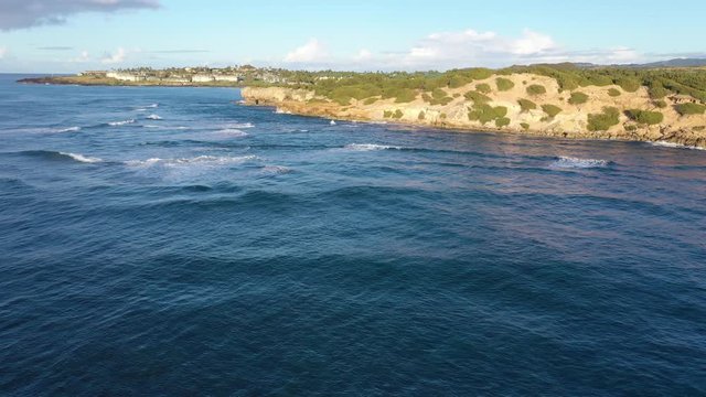 Low elevation arial video chasing, following, waves as they approach the rocky coast and finally break, Shipwreck Beach #1, Poipu, Koloa, Kauai, Hawaii