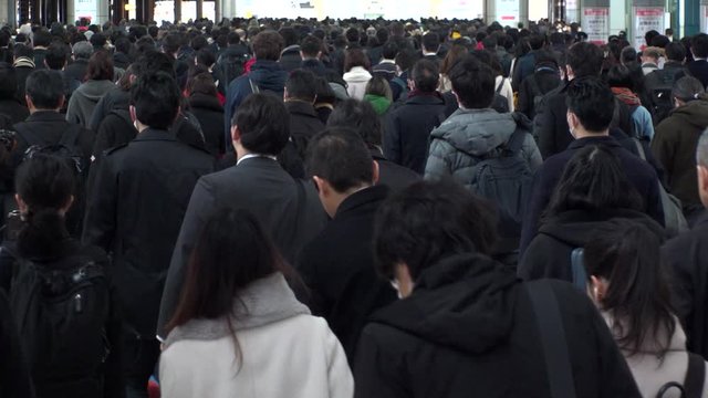SHINAGAWA, TOKYO, JAPAN - MARCH 2020 : Crowd of people walking down the street in busy morning rush hour. Many commuters going to work. Japanese business, job and lifestyle concept. Slow motion shot.