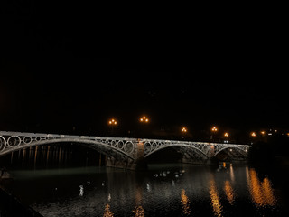 Fototapeta na wymiar Triana Bridge from the Guadalquivir River at night.