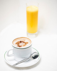 Cafe en taza blanca con linea verde y mantel blanco
